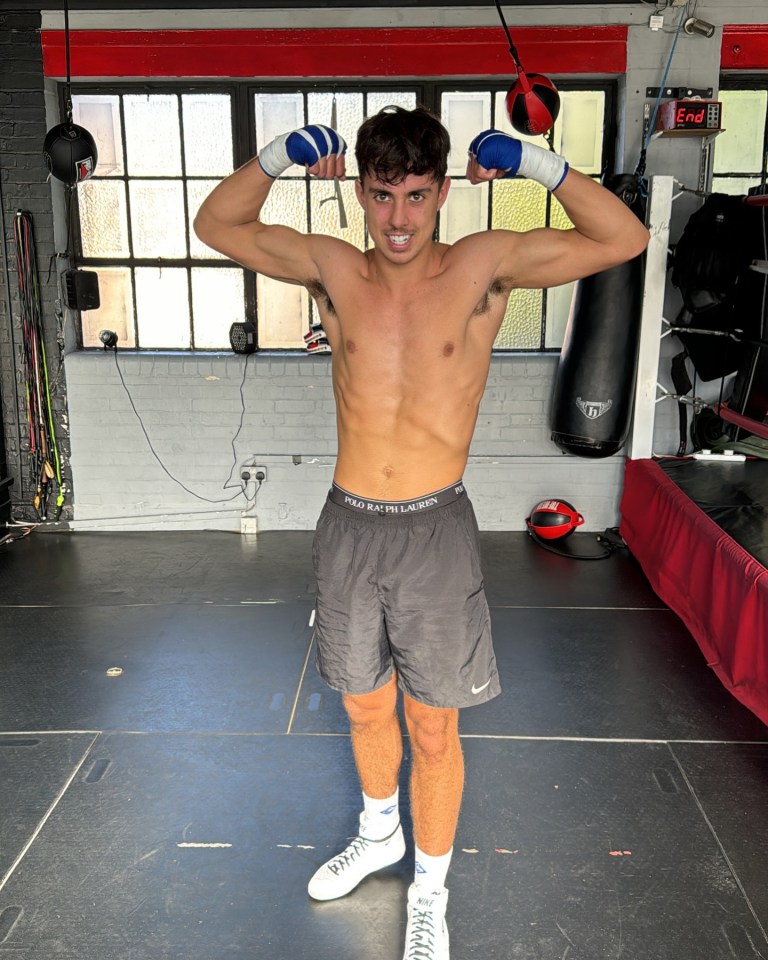 Boxer flexing in boxing gym.
