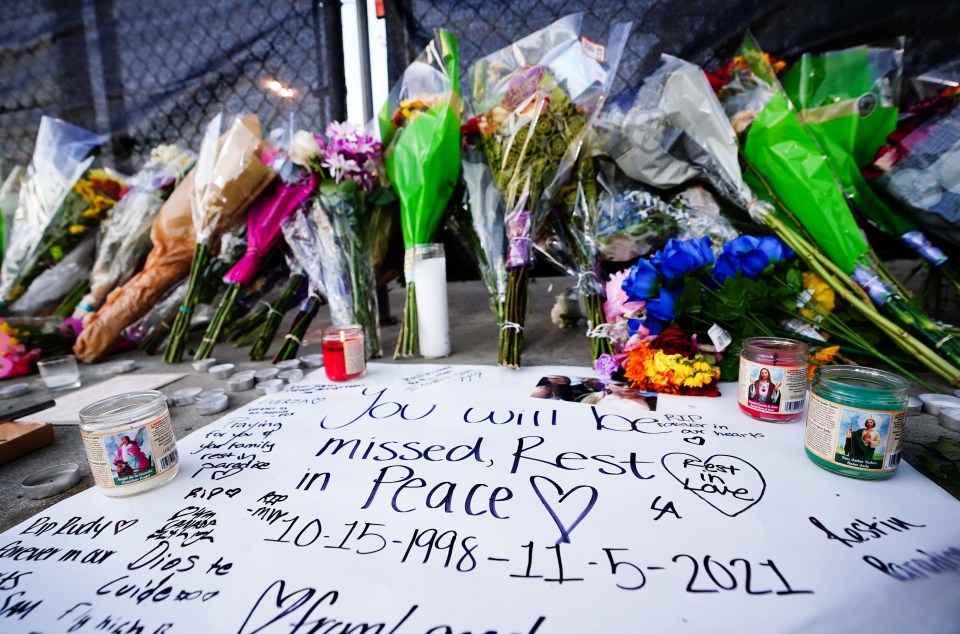 Memorial with flowers, candles, and messages for Astroworld victims.
