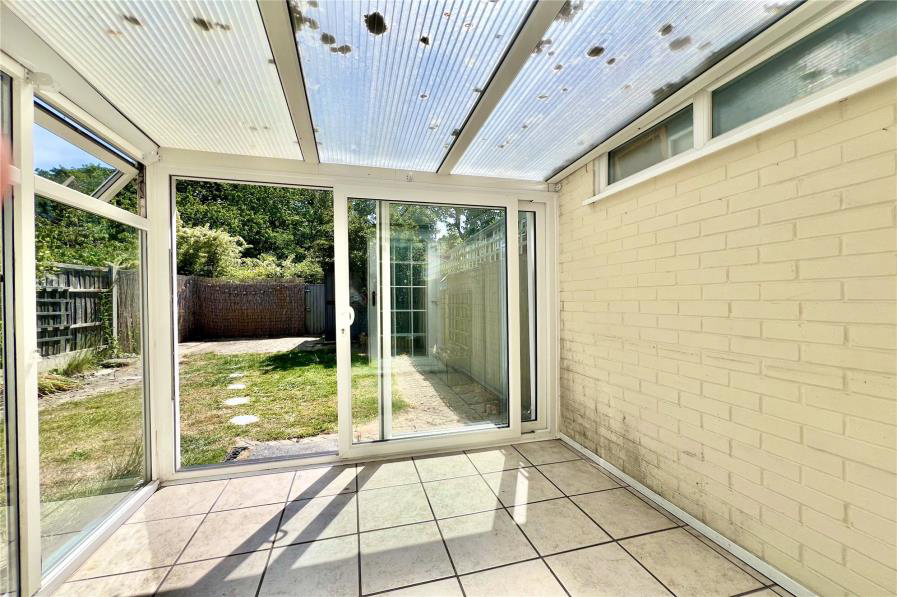 Interior view of a sunroom overlooking a garden.