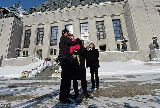 Lee Carter, right, and her husband Hollis Johnson embrace outside The Supreme Court of Canada in Feb. 2015 after MAID legislation is approved
