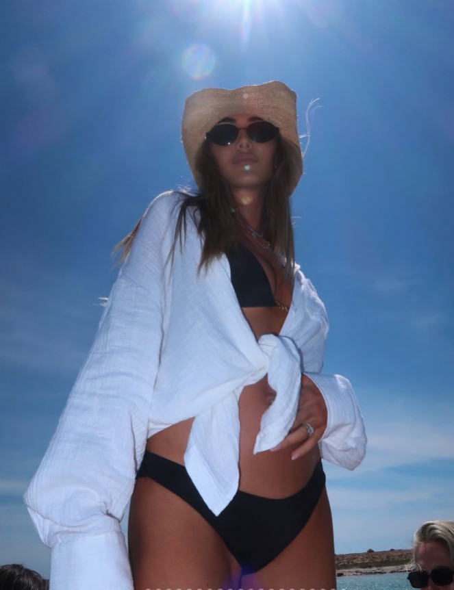 Sophie Habboo, wearing a hat and sunglasses, showing her baby bump.