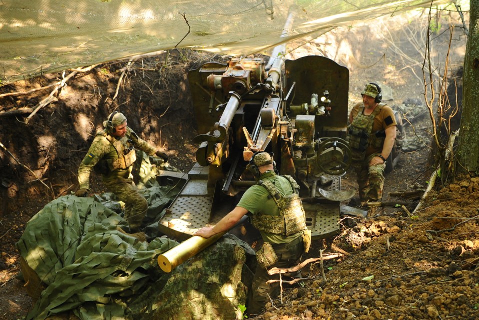 Ukrainian soldiers preparing to fire a cannon.