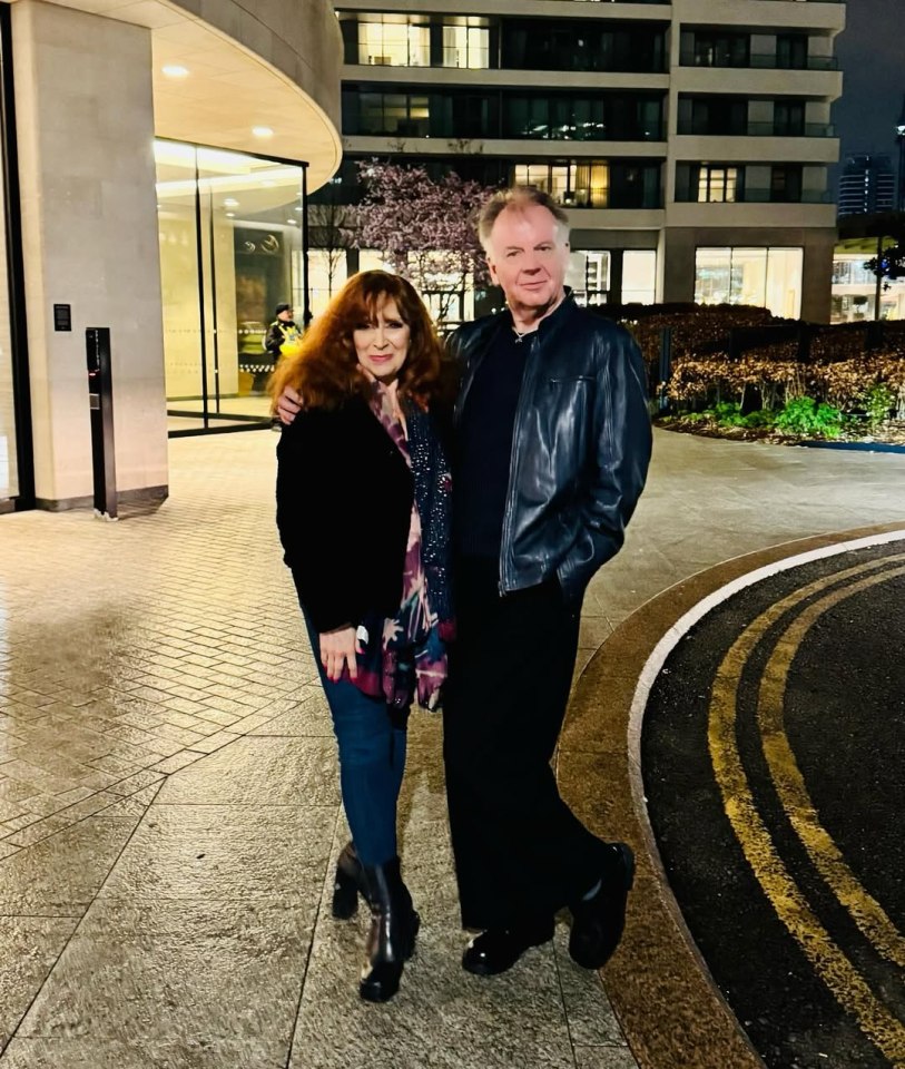 Photo of a man and woman standing outside at night.