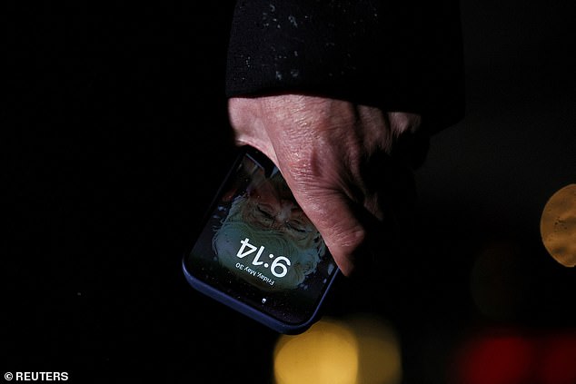 Here President Donald Trump holds a mobile phone with his image on it, after his return from Pennsylvania