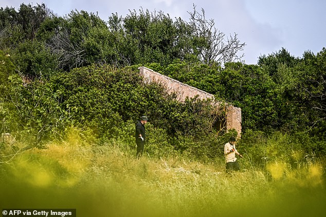 Criminal Investigators stand in a field near ruins during the new search operations