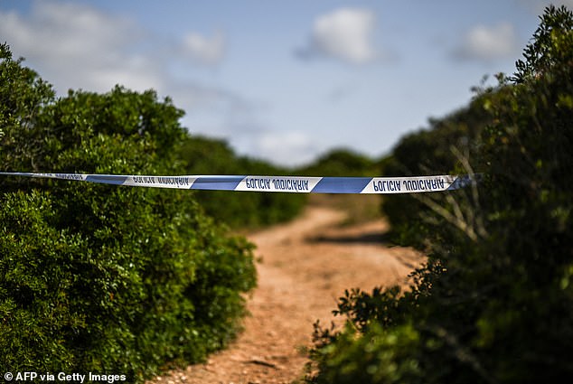 A police cordon is seen at the site, which is a mix of shrubland and woodland by the coast