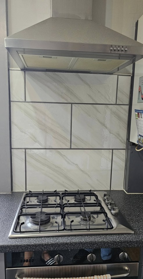 Kitchen makeover: new stove and marble-look backsplash.