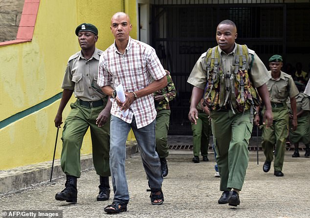 Jermaine Grant (centre, in a plaid shirt) is led away to begin his sentence on bomb-making charges in 2019