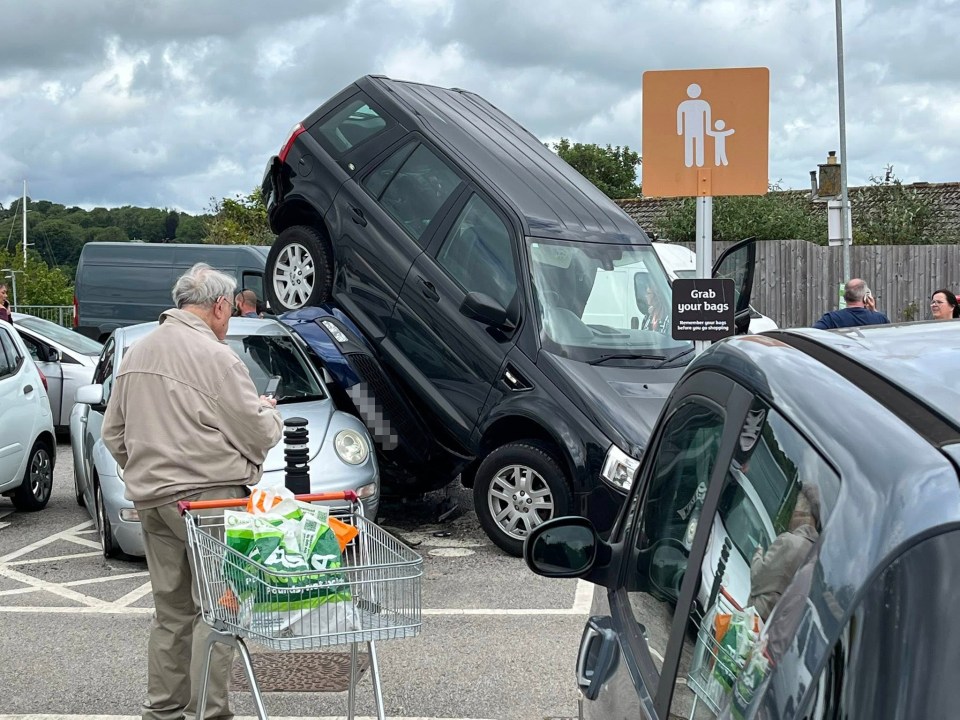 Car on top of another car in a parking lot.