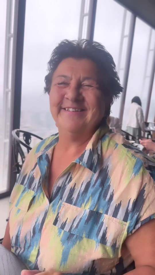 Smiling woman in patterned shirt.