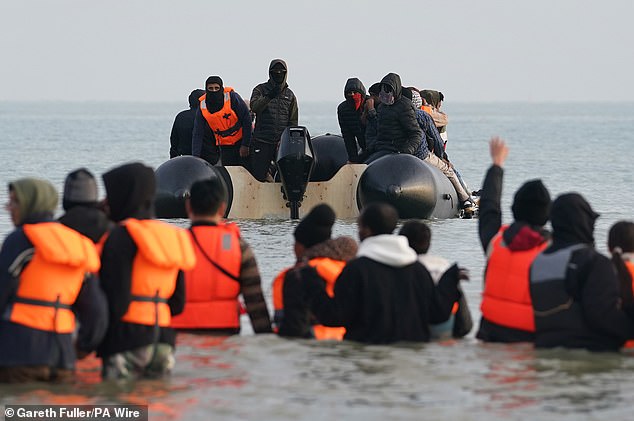 People hoping to reach the UK to claim asylum wade into the Channel to catch a dinghy piloted by several men