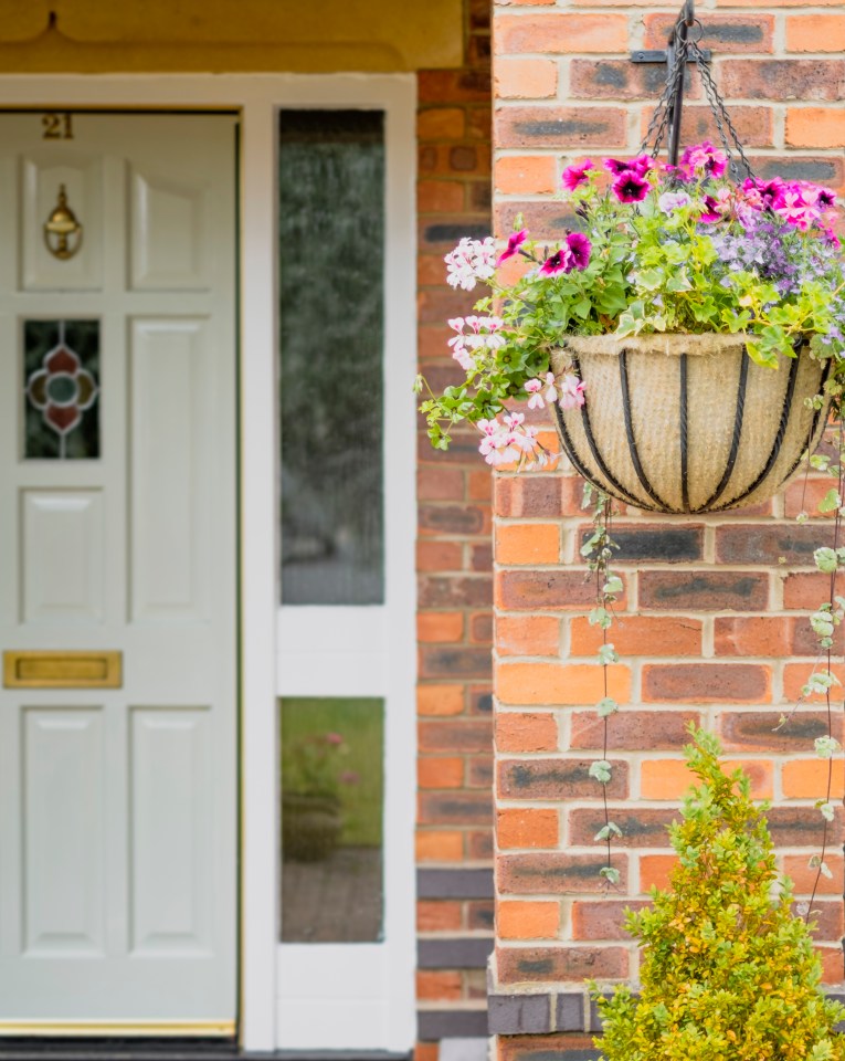 Hanging basket of flowers on a brick house.