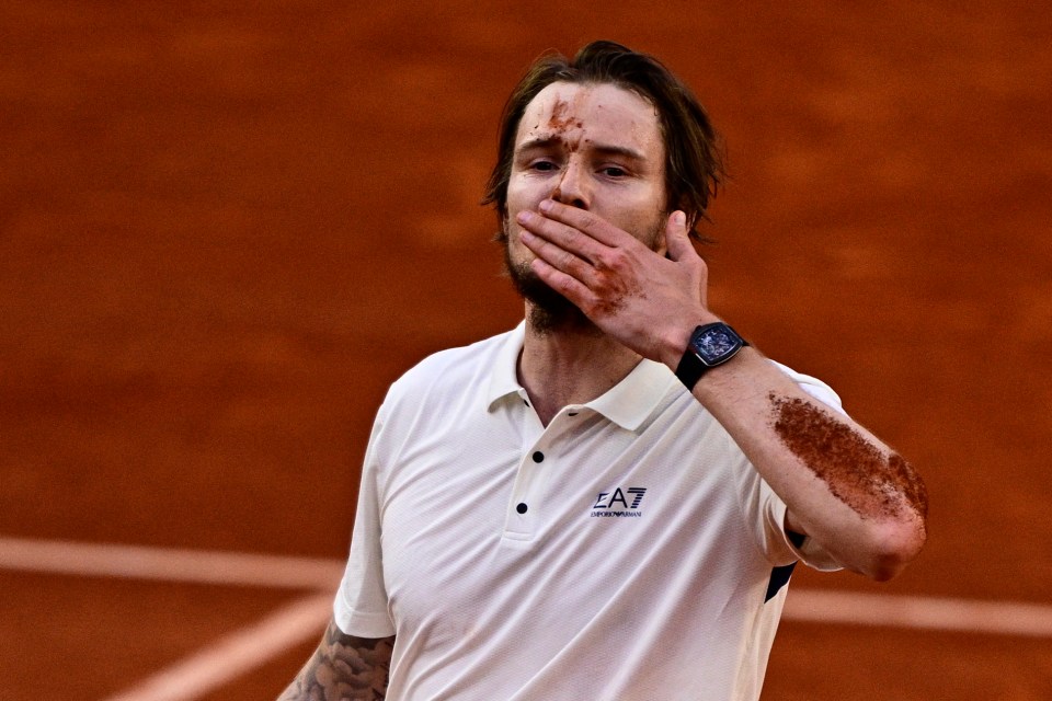 Alexander Bublik celebrates a tennis match victory.