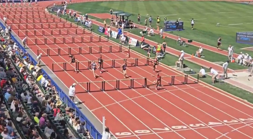 Track and field athletes hurdle race.