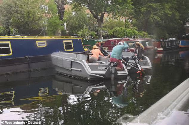 A group of people operating the GoBoats can be seen crashing into the side of a parked barge along the canal