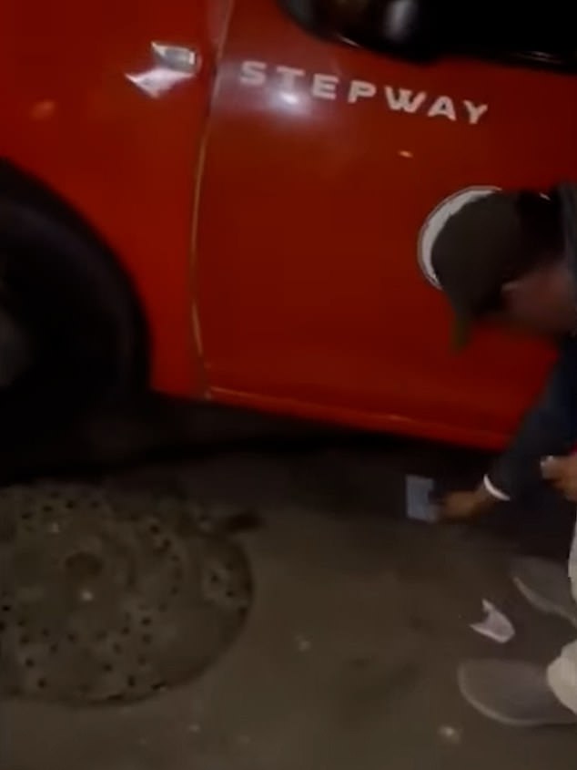 Grabbing the note off the floor, the driver then jumps into his car to drive away as the women continue to hurl insults at him