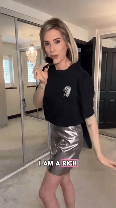 Woman applying makeup in front of a mirror.