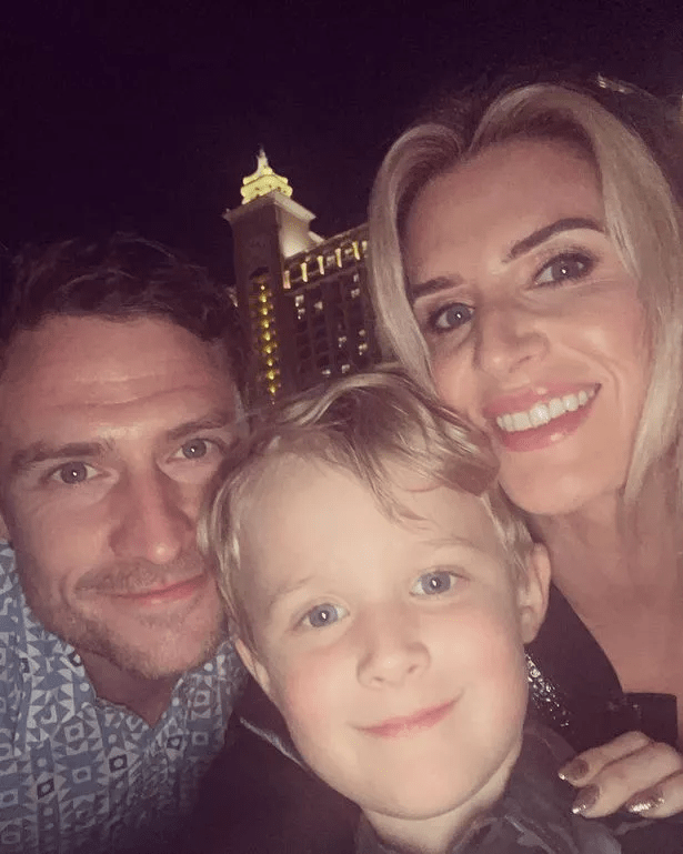 Family selfie with a building in the background.