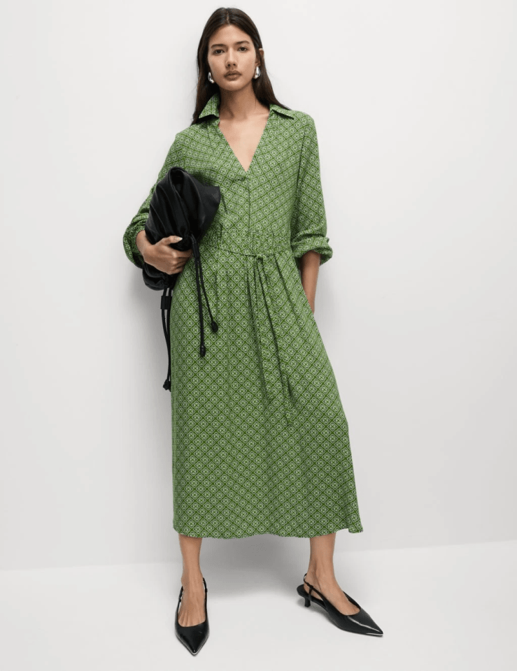 Woman in green patterned midi dress and black shoes.