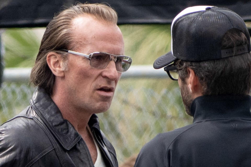Christian Bale on the set of "Madden," wearing a leather jacket and sunglasses.