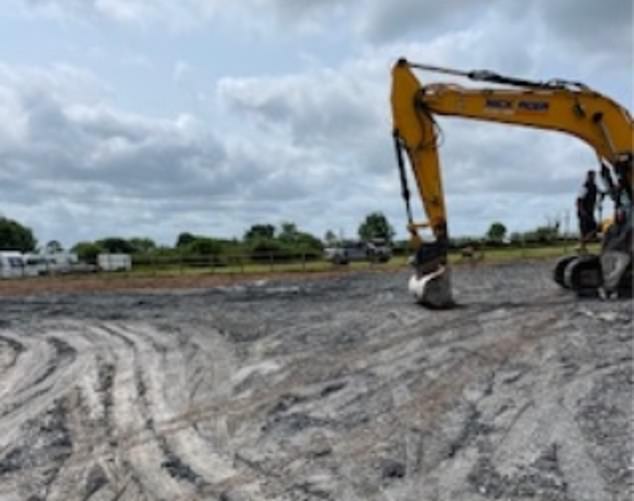 A JCB is pictured on the field on Tuesday afternoon, with caravans parked at the end of the site