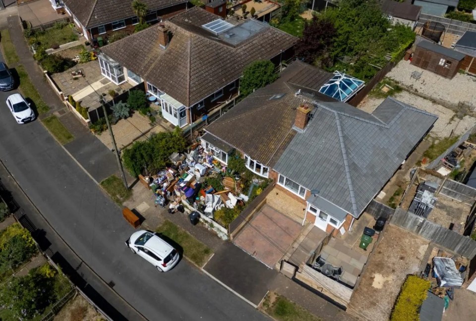 Aerial view of a house with a yard full of discarded items.