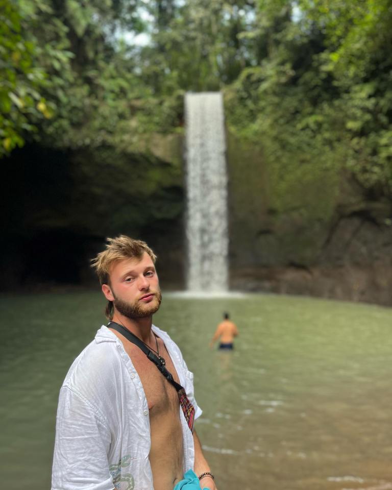 Man standing near a waterfall.