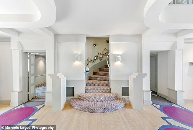 One of the staircases is awash in a soft pink carpeting