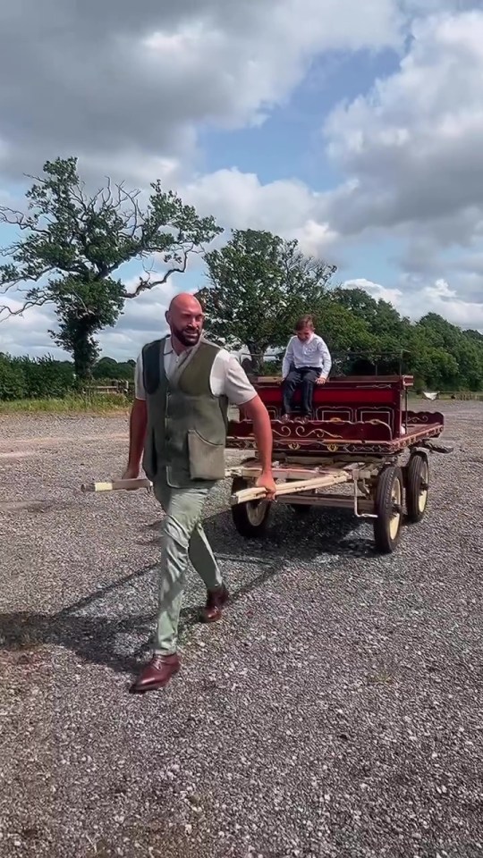 Tyson Fury pulling a horse-drawn cart with his son in it.