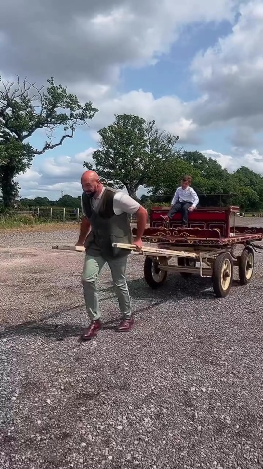 Tyson Fury pulling a horse-drawn cart with his son inside.