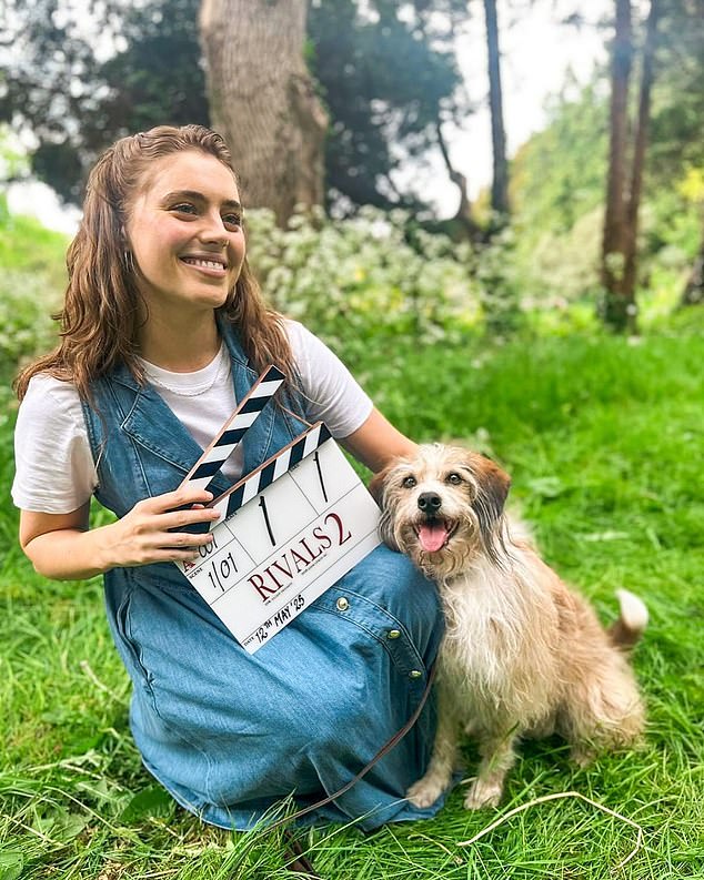 Actress Bella Maclean (pictured) was all smiles as she held a clapperboard while cuddling up to a cute pooch