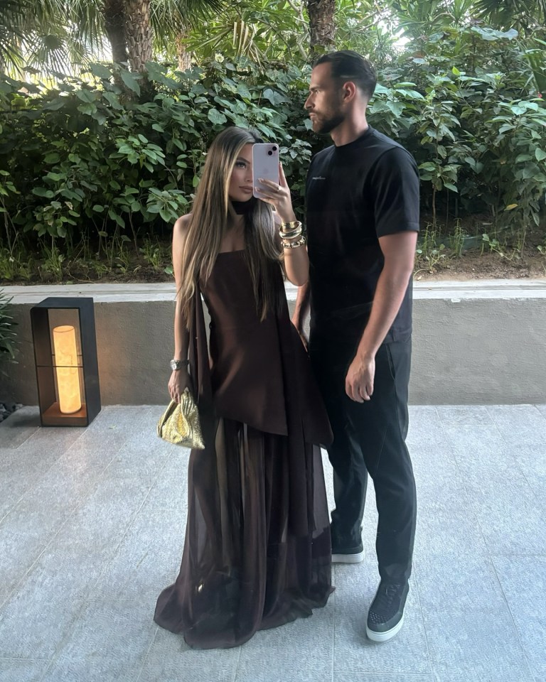 Woman in brown dress and man in black shirt taking a selfie.