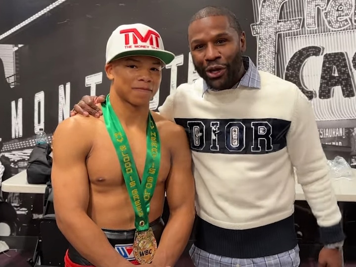 Young boxer with a gold medal and older man.