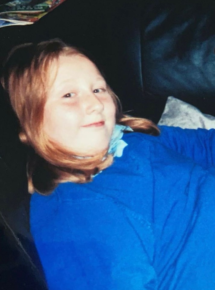 Photo of a young girl with blond hair wearing a blue shirt.