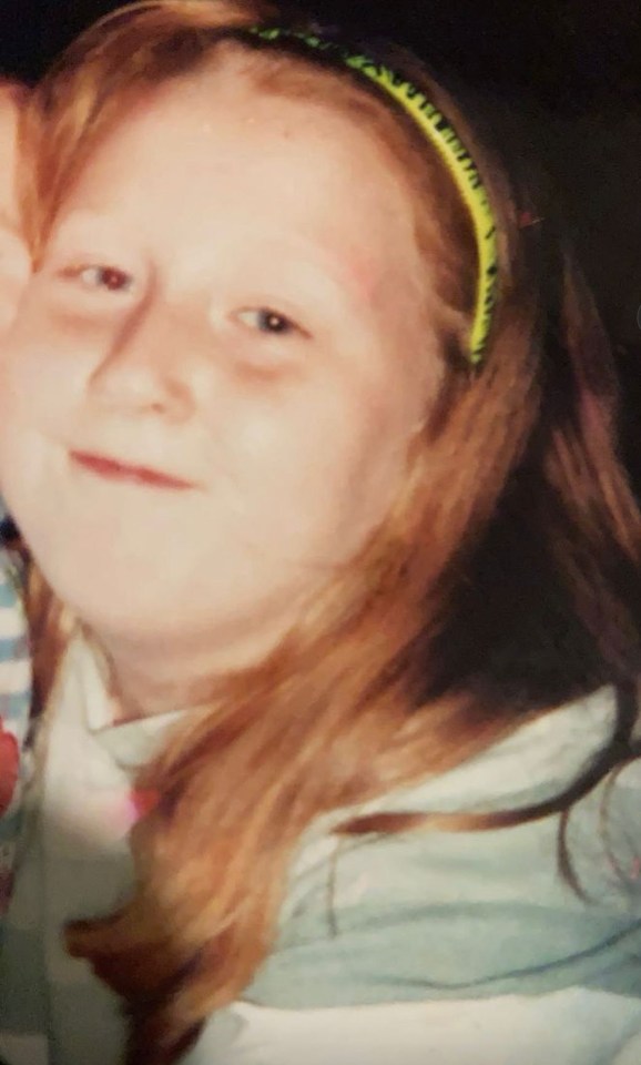 Photo of a young girl with long, light brown hair and a headband.