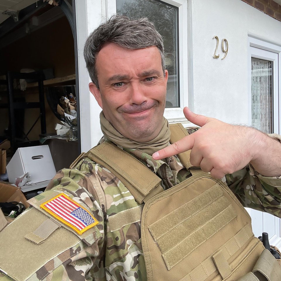 Man in military uniform points to his vest.