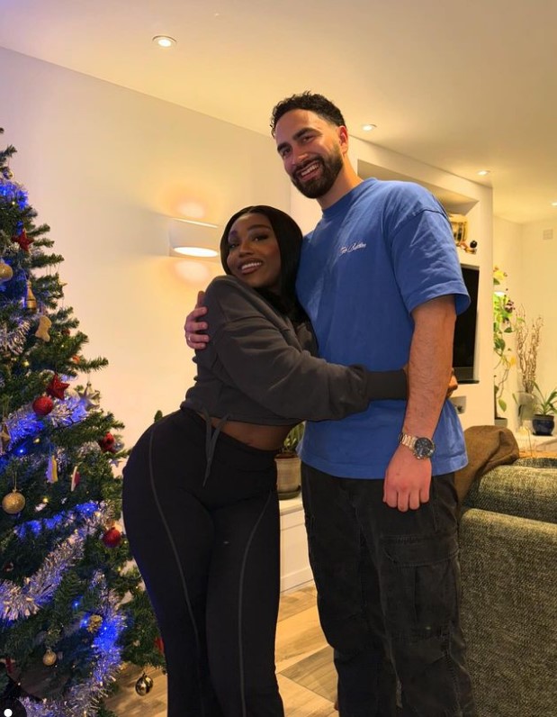 Whitney Adebayo and Lochan hugging in front of a Christmas tree.