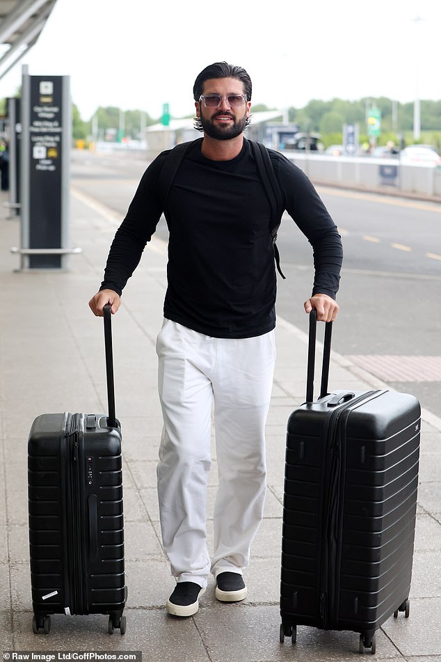 Dan looked dapper in a long-sleeved black top and white trousers