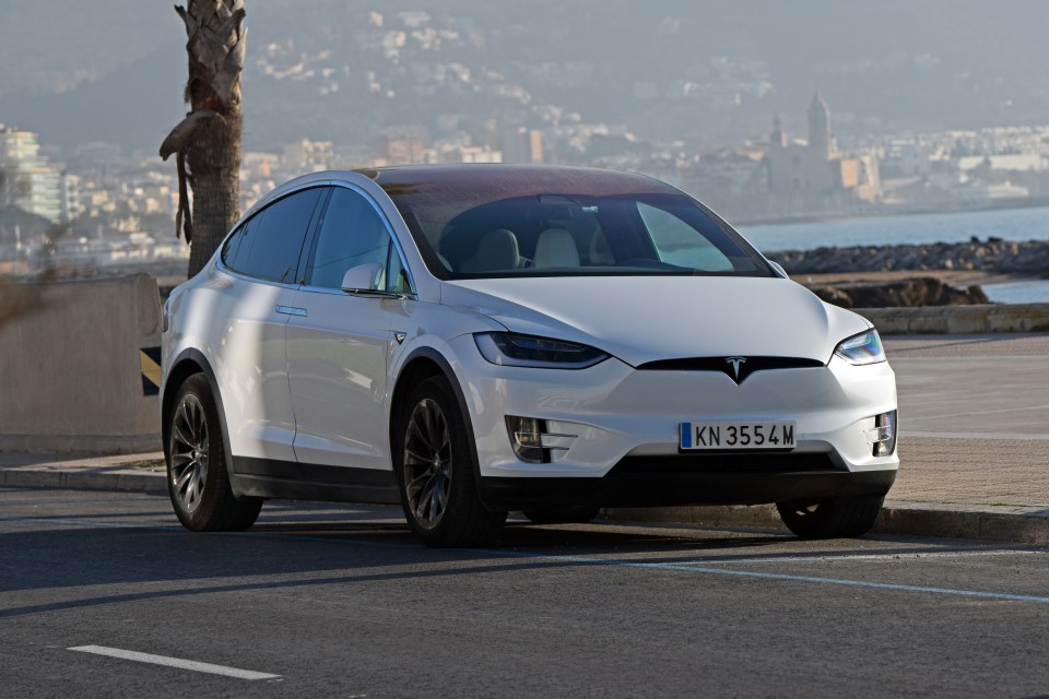 White Tesla Model X parked on a city street.