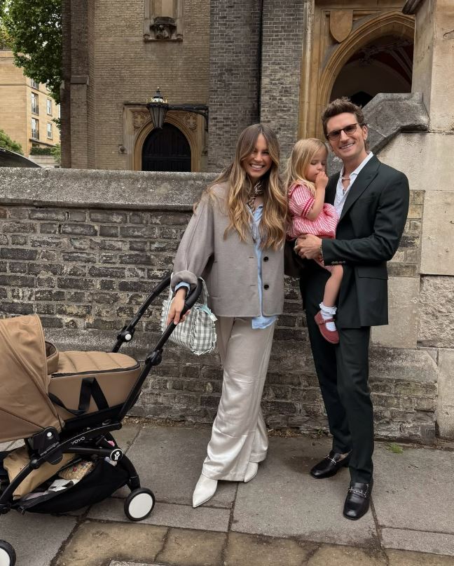 Family with a baby in a stroller outside a church.