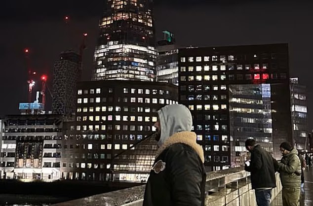 Zahir wearing a hoodie while posing for a photo on a bridge in central London