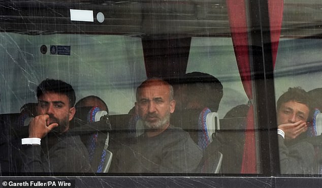 Migrants are driven away from the Border Force base in Dover in Kent on Saturday