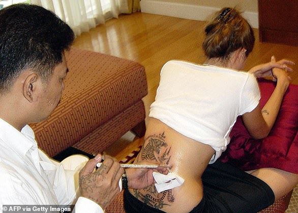Her tattoo artists are Sompong Kanphai for traditional Thai tattoos, including the iconic Bengal tiger on her back. Mark Mahoney has also been a frequent choice, designing and applying intricate designs like the Stay Gold tattoo and the recent dainty bird tattoo. Mr. K has worked on her hands, and Bang Bang tattoo studio has also been involved.