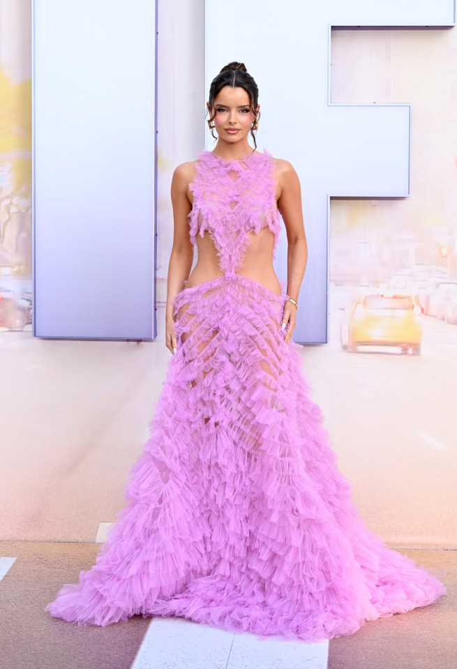 Maura Higgins in a pink ruffled gown at a film premiere.
