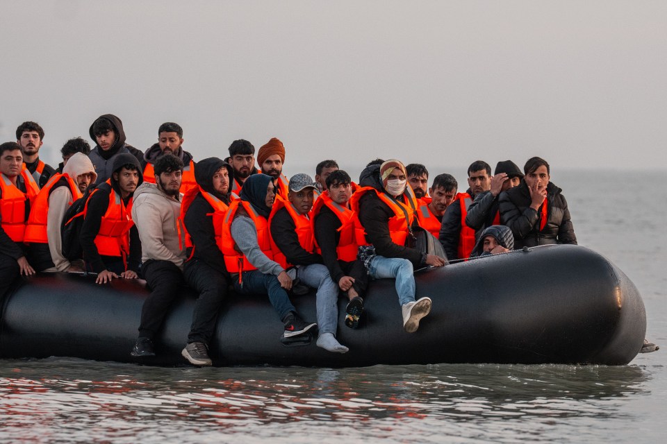 Migrants in life vests aboard a small inflatable boat.