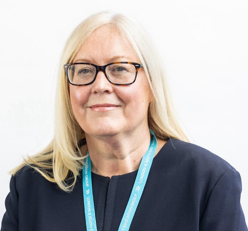 Portrait of a woman wearing glasses and a lanyard.