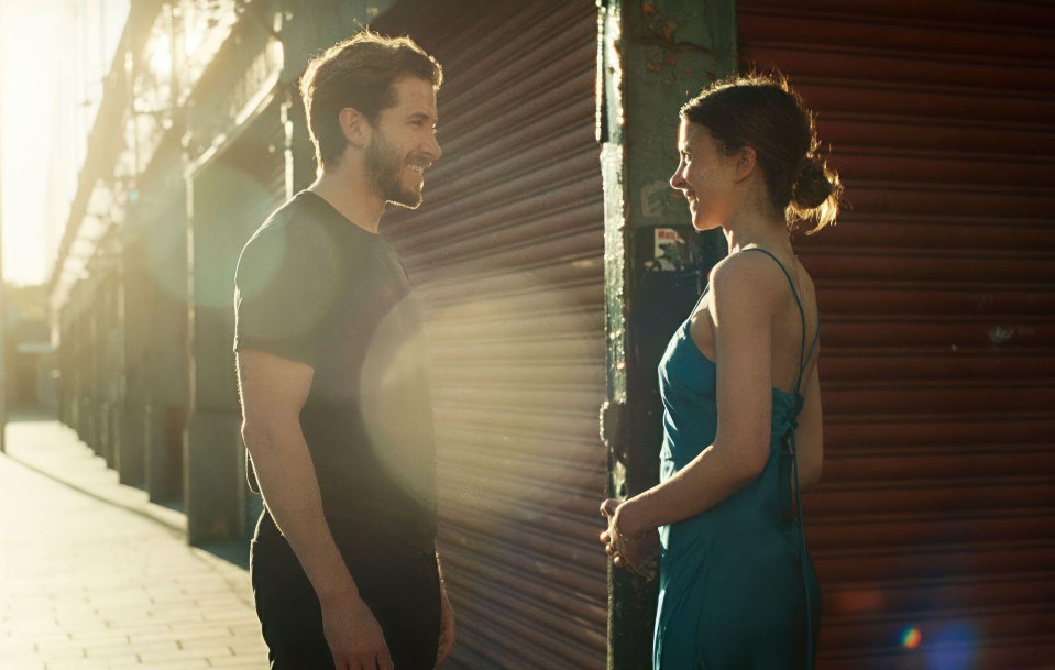 A man and woman facing each other on a city street.