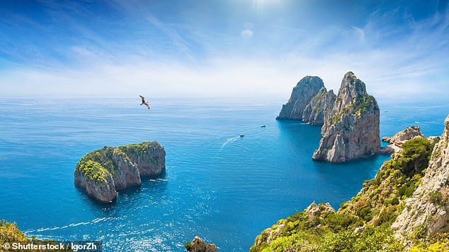 As we plunge across the Mediterranean, the boats criss-crossing below look like Lego, and in no time we¿re hovering above the Faraglioni Rocks, three giant sea stacks that mark the entry to Capri (pictured)