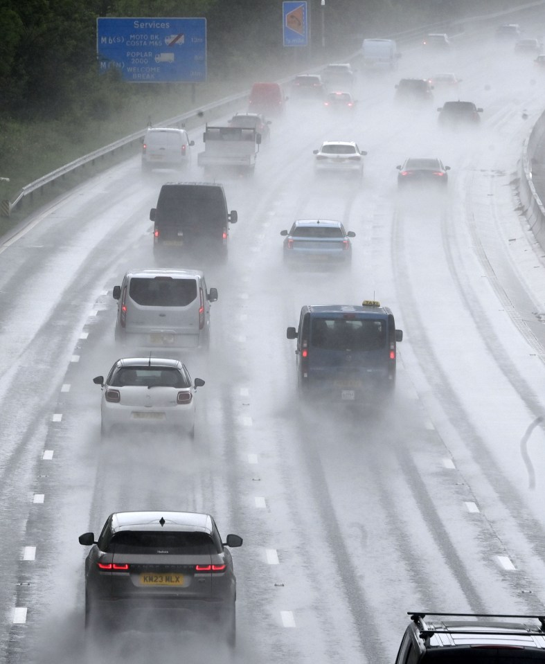 Cars driving on a rain-soaked highway.