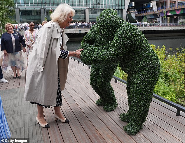 Queen Camilla meets two people dressed as hedges during the Big Lunch at Eden Dock in London's Canary Wharf